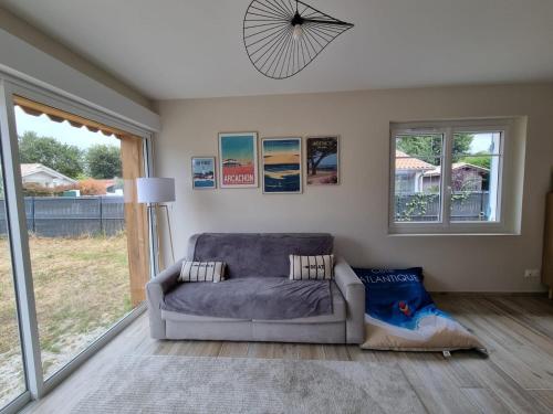 un salon avec un canapé et une grande fenêtre dans l'établissement La maison du Bassin, 500 m de la plage à Andernos, à Andernos-les-Bains
