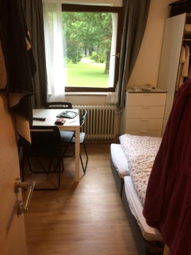a bedroom with a bed and a desk and a window at Grubhof in Sankt Martin bei Lofer