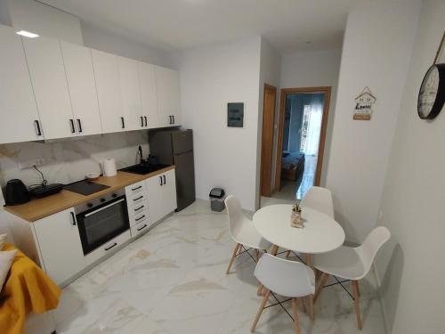 a kitchen with a table and chairs and a kitchen with a stove at Kilkis Central Apartment 2 in Kilkís
