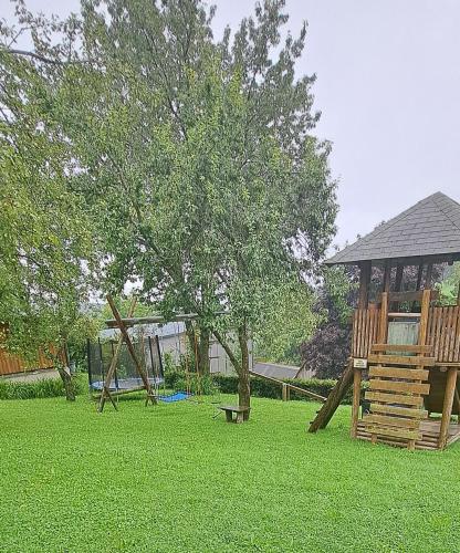 a playground with a tree and a swing set at Ferienwohnung Auer in Tulwitzdorf