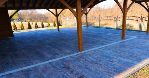 a large empty patio with a fence and trees at Apartamenty pod Dębami - noclegi Beskid Niski in Odrzechowa