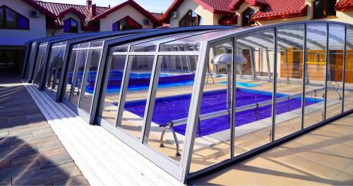 a glass house with a pool inside of it at Apartamenty pod Dębami - noclegi Beskid Niski in Odrzechowa