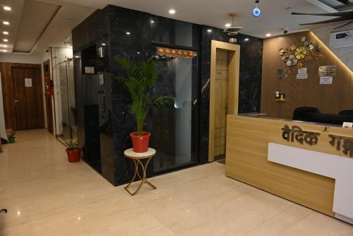 a lobby with a potted plant on the wall at Hotel Vaidik Ganga in Rishīkesh