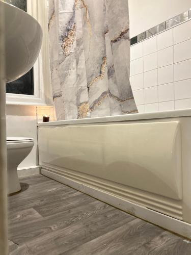 a bathroom with a white tub and a toilet at Accommodatez in Hartlepool