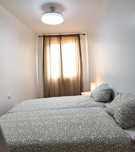 a bedroom with a large bed and a window at La Jara in Fuenmayor