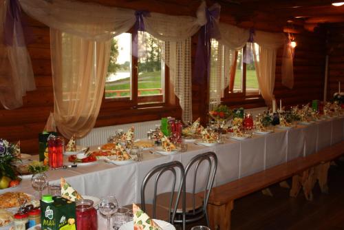 a long table with a white table cloth at Atpūtas komplekss " Ezerkrasti" in Čornaja