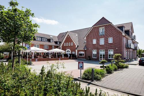 a large red brick building with a courtyard at Hotel Neuwarft in Dagebüll