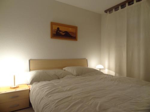 a bedroom with a white bed and a picture on the wall at Haus Sarah in Brigerbad