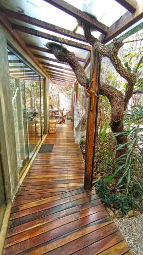 a wooden walkway leading to a house with a tree at Vila Abaton in Alto Paraíso de Goiás