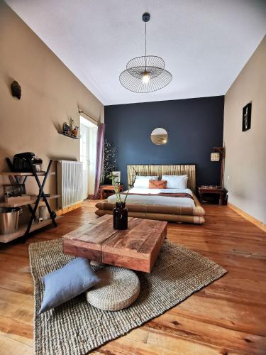 une chambre avec un lit et une table en bois dans l'établissement Moulin de Monpoisson, à Le Puy