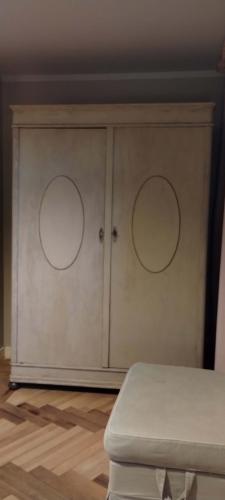 a white cabinet with two doors on a wall at PATEK Premium Apartments - Airport Lawica & MTP & Car races & International trade fairs in Skórzewo