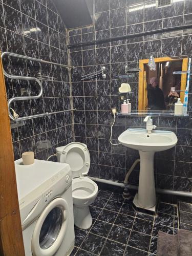 a bathroom with a toilet and a sink and a washing machine at 2 комнатные аппартаменты на бульваре Пушкина in Kremenchuk