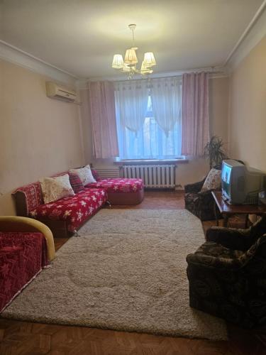 a living room with a red couch and a tv at 2 комнатные аппартаменты на бульваре Пушкина in Kremenchuk