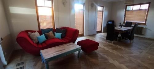 a living room with a red couch and a table at PATEK Premium Apartments - Airport Lawica & MTP & Car races & International trade fairs in Skórzewo