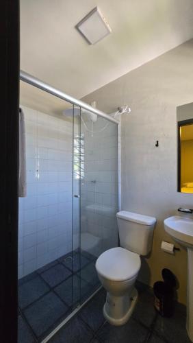 a bathroom with a toilet and a shower and a sink at Estação Hotelaria in São Gabriel