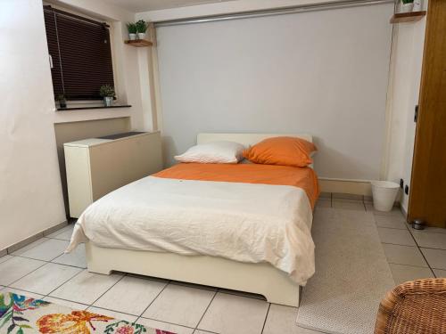 a bedroom with a bed with an orange and white blanket at Villa Casa Blanca mit Privatem Schwimmbad 26 grad und Sauna in Duisburg