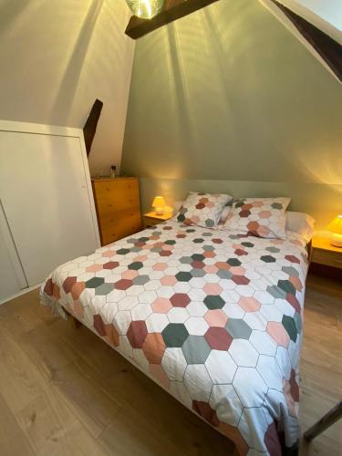 une chambre avec un lit avec une couette dessus dans l'établissement La Paisible - Maison 6 pers piscine - Le Mans centre, au Mans