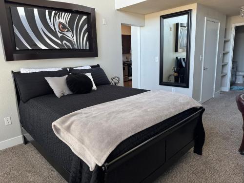 a bedroom with a large black bed with a mirror at Vanity 2 Bedroom Loft Downtown Ft Worth in Fort Worth