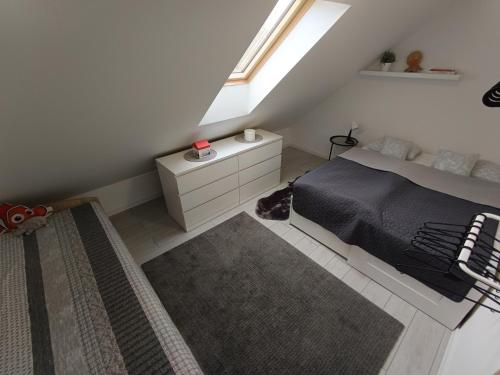 a attic bedroom with a bed and a window at Apartman Nábrežná in Nové Zámky