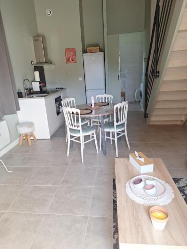 une cuisine et une salle à manger avec une table et des chaises dans l'établissement La renaissance, à Lesparre-Médoc