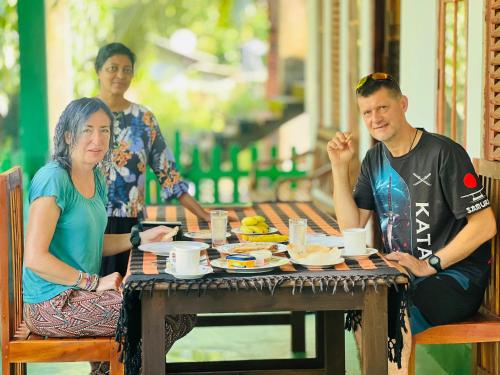 a man and woman sitting at a table with food at Jm Resort in Dambulla