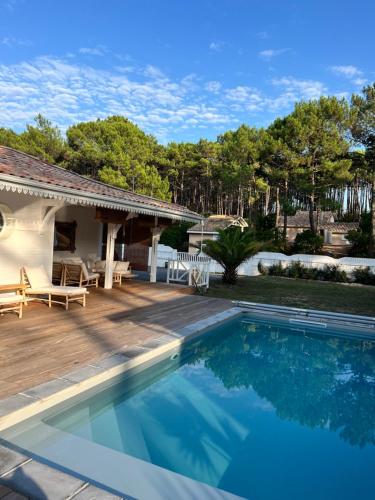 une piscine devant une maison dans l'établissement LA VILLA DES PINS, à Lacanau-Océan