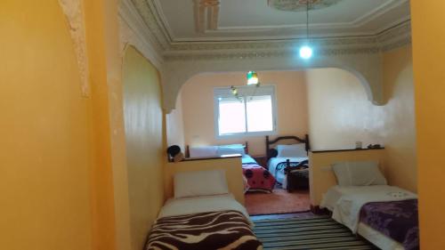 a room with two beds and a window at Maison D'hote Amazir in Boumalne