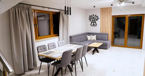 a living room with a table and chairs and a couch at Apartamenty pod Dębami - noclegi Beskid Niski in Odrzechowa