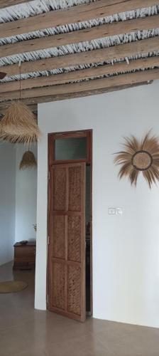a room with a wooden door and a ceiling at Amka Guest house in Jambiani