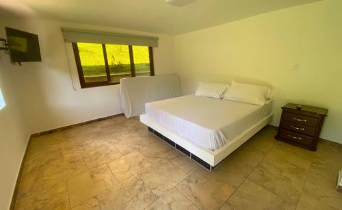 a bedroom with a bed and a dresser and a window at Chalets Villa Marina in Copacabana
