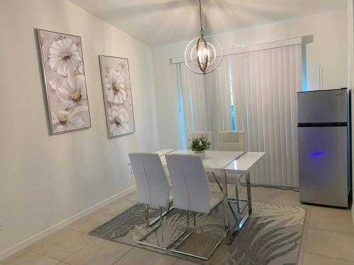 a dining room with a table and chairs and a refrigerator at The Elegant Suite in Shared House in Cape Coral