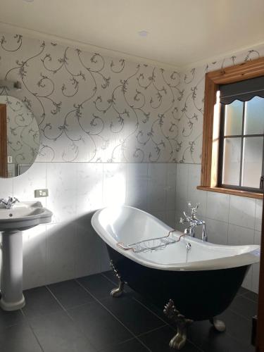 a bathroom with a large tub and a sink at Fantail Cottage in Hurunui