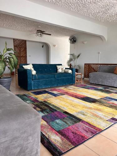 a living room with a blue couch and a rug at 428 Boutique Guesthouse in Boscobel