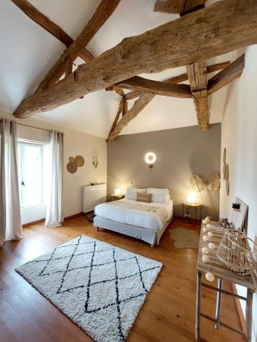 ein Schlafzimmer mit einem weißen Bett und Holzdecken in der Unterkunft Moulin de Monpoisson in Le Puy