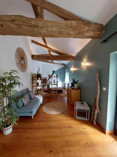 ein Wohnzimmer mit einem blauen Sofa und Holzdecken in der Unterkunft Moulin de Monpoisson in Le Puy
