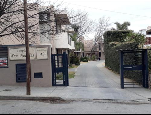 eine leere Straße mit einem blauen Tor vor einem Gebäude in der Unterkunft Dos Nogales 26 in Villa Carlos Paz