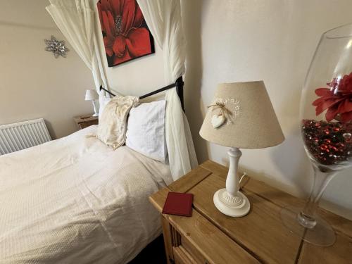 a bedroom with a bed and a lamp on a table at The Kings Head inn in Addlethorpe