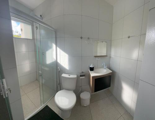 a white bathroom with a toilet and a sink at Pousada Hércules Beach Paradise in Maragogi
