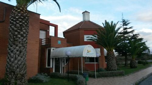 a red brick building with a white awning and palm trees at Hotel Casa Fernando II in Rellayo