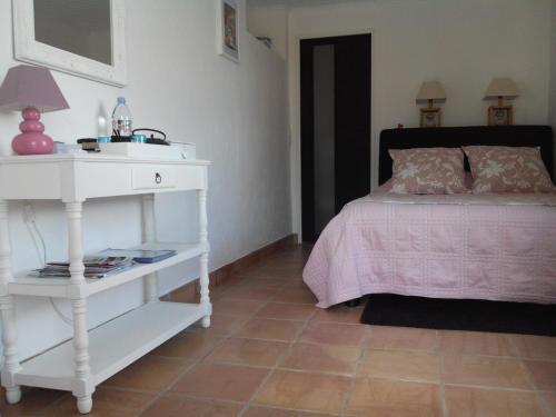 1 dormitorio con cama blanca y mesa blanca en villa des oliviers, en Le Tignet