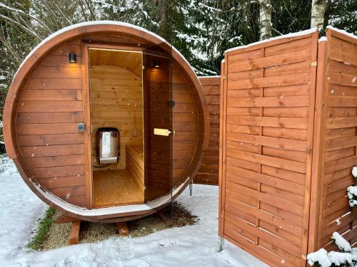 eine Holzsauna im Schnee mit einem Holzgebäude in der Unterkunft Domki na granicy in Jeżowski Dział