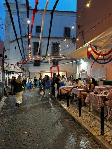 a group of people sitting at tables in a restaurant at Cantinho das Portas do Sol in Lisbon