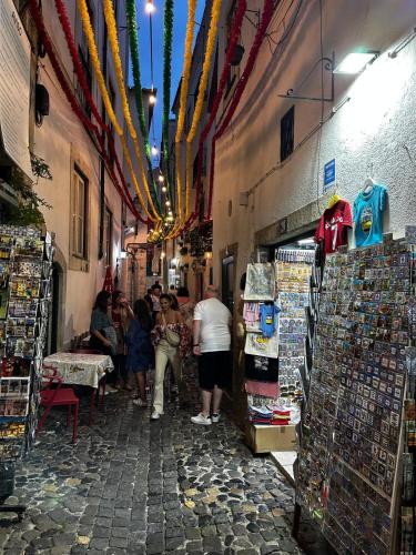 a group of people standing in a narrow alley at Cantinho das Portas do Sol in Lisbon