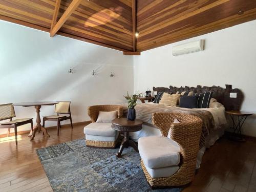 a living room with a bed and a table and chairs at Alma Hotel in Campos do Jordão