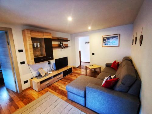 a living room with a couch and a television at Appartamenti Daberto Fabiola in Arabba