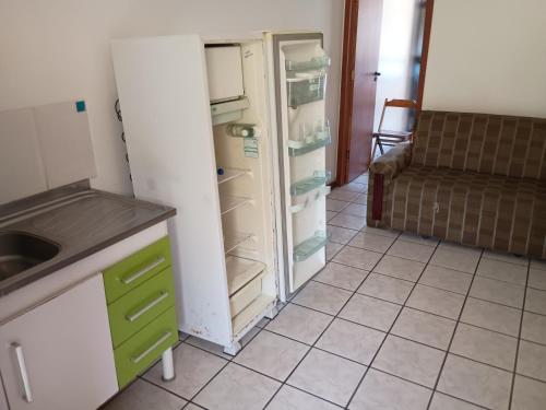 a kitchen with an open refrigerator and a couch at Pousada do caju in Serra
