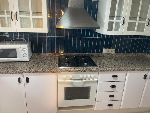 a kitchen with a stove and a microwave at Altea Beach in Altea