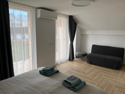 a bedroom with a bed with two towels on it at Panacea in Lazdijai