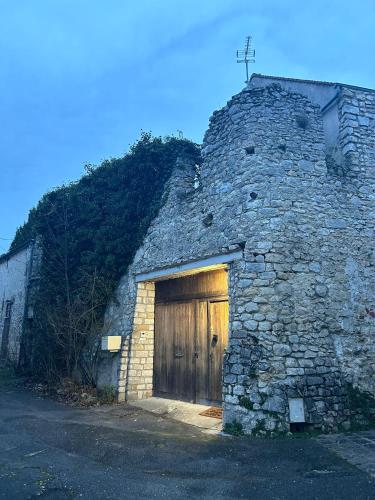 - un bâtiment en pierre avec une porte en bois et une croix au-dessus dans l'établissement Muraille du château avec jacuzzi, à Nemours