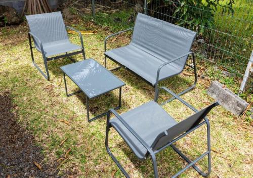 a group of three chairs and a table at Maison cosy en bord de mer-wifi et parking gratuit in Saint-Joseph